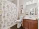 Practical bathroom with a wood-look floor, decorative shower curtain, and functional vanity at 149 Manor Lane, Woodstock, GA 30188