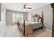 Cozy bedroom featuring a wooden bed frame, ceiling fan, and natural light from the window at 149 Manor Lane, Woodstock, GA 30188