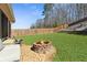 Backyard fire pit area on a stone base with seating, surrounded by lush green lawn at 149 Manor Lane, Woodstock, GA 30188