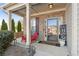 Inviting front porch with a red chair, decorative sign, and well-maintained landscaping at 149 Manor Lane, Woodstock, GA 30188