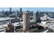 An aerial view shows a tall condominium building surrounded by the cityscape on a clear day at 3481 Lakeside Ne Dr # 2207, Atlanta, GA 30326