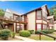 Inviting two-story condo with beige siding, red trim, a balcony, and lush landscaping at 904 Wentworth Ct, Alpharetta, GA 30022