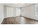 A bedroom featuring light gray walls, wood floors and a window at 2460 Millwater Crossing Xing, Dacula, GA 30019