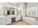 Bright bathroom with double sink vanity, soaking tub, and tiled accents at 2460 Millwater Crossing Xing, Dacula, GA 30019