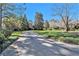 Long driveway leading to a grand brick home surrounded by mature trees at 3000 Rivermeade Nw Dr, Atlanta, GA 30327