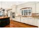 Bright kitchen with brick accents, white cabinetry, and stainless steel appliances at 3000 Rivermeade Nw Dr, Atlanta, GA 30327