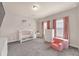 Bedroom with pink decor, including a crib, chair, and curtains, under a lit ceiling fan at 6441 Se Brookside Blvd, Mableton, GA 30126