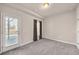 Simple bedroom featuring a door to the outside with blinds, and a window with dark curtains at 6441 Se Brookside Blvd, Mableton, GA 30126