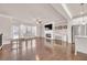 Open living room featuring hardwood floors, a cozy fireplace, and abundant natural light from large windows at 6441 Se Brookside Blvd, Mableton, GA 30126