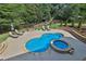 Aerial view of a pool and spa surrounded by professionally landscaped backyard at 102 Glenmill Way, Woodstock, GA 30188