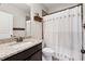 Bathroom featuring granite countertop, dark wood cabinetry, a framed mirror, and a shower with decorative curtain at 102 Glenmill Way, Woodstock, GA 30188