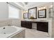 Elegant bathroom features a soaking tub, dual vanities with granite counters and decorative mirrors at 102 Glenmill Way, Woodstock, GA 30188