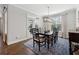 Bright dining room has large windows, a stylish chandelier, and an elegant table for six at 102 Glenmill Way, Woodstock, GA 30188