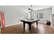 Finished game room with hardwood floors, a ping pong table, a modern light fixture, and large windows at 102 Glenmill Way, Woodstock, GA 30188