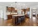 The kitchen features dark wood cabinetry, granite countertops, stainless steel appliances and a large island with seating at 102 Glenmill Way, Woodstock, GA 30188