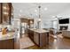 Kitchen view with stainless appliances, large island, and the living room with a cozy fireplace at 102 Glenmill Way, Woodstock, GA 30188