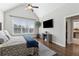 Light-filled main bedroom features a vaulted ceiling, TV, and a large window overlooking the yard at 102 Glenmill Way, Woodstock, GA 30188