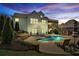 Backyard oasis features a sparkling pool with waterfall feature, patio, and lush landscaping at 102 Glenmill Way, Woodstock, GA 30188