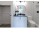 Modern bathroom featuring a sleek vanity with a black countertop, mirror, toilet, and tiled shower at 158 Palisade Dr, Rydal, GA 30171