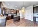 Stylish kitchen featuring an island, stainless steel appliances, dark wood cabinets, and gleaming hardwood floors at 830 Pine Arbor Ln, Lawrenceville, GA 30043