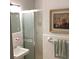 Bathroom with white tiling, glass shower doors, framed painting, and a fresh green towel at 307 Adair St # 7-E, Decatur, GA 30030