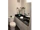 Bathroom featuring a black countertop vanity, toilet, vanity mirror, and modern accessories at 307 Adair St # 7-E, Decatur, GA 30030