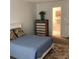 Cozy bedroom with a soft blue bedspread, dresser, and a view of the tiled en suite bathroom at 307 Adair St # 7-E, Decatur, GA 30030
