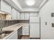 Galley kitchen featuring white cabinets, modern backsplash, stainless steel appliances, and light countertops at 307 Adair St # 7-E, Decatur, GA 30030