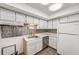 Compact kitchen with white cabinets, stainless steel dishwasher, and decorative backsplash at 307 Adair St # 7-E, Decatur, GA 30030