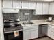 This is a cozy kitchen with white cabinets, stainless steel appliances and a modern backsplash at 307 Adair St # 7-E, Decatur, GA 30030