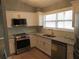 Updated kitchen featuring stainless steel appliances, granite countertops, and bright, white cabinetry at 6832 Shangrila Way, Riverdale, GA 30296