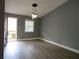 Comfortable living room featuring vinyl flooring, neutral paint, modern lighting, and an exterior access door at 6832 Shangrila Way, Riverdale, GA 30296