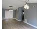 Bright living room featuring vinyl flooring, neutral paint, modern lighting, and a glass paned patio door at 6832 Shangrila Way, Riverdale, GA 30296