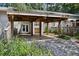 Carport featuring a wood beam support structure with rear home entrance and green landscaping at 2106 Clairmeade Valley Ne Rd, Atlanta, GA 30329