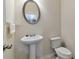 Cozy half-bathroom features a pedestal sink, oval mirror, and a standard toilet at 3158 Onamia Rd, Duluth, GA 30096