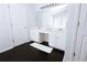 Bright bathroom featuring double sinks, white cabinetry, large mirror, and dark hardwood floors at 4617 Stone Lane, Stone Mountain, GA 30083