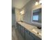 Bathroom featuring double sinks with granite countertops, tile flooring and modern fixtures at 554 Presley Farm Parkway, Rockmart, GA 30153