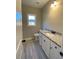 Bathroom featuring a granite countertop, white cabinets with black hardware, and gray tile flooring at 554 Presley Farm Parkway, Rockmart, GA 30153