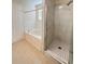 Bright bathroom featuring a tub and a separate glass-enclosed shower with white marble-style tiling at 1418 Brookside Manor Ct, Tucker, GA 30084