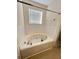Bathroom features a tub with white tile backsplash at 1418 Brookside Manor Ct, Tucker, GA 30084