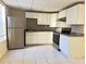 A kitchen with white cabinetry, gray counters, stainless steel appliances, and tile flooring at 1418 Brookside Manor Ct, Tucker, GA 30084