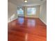 Open living room with gleaming hardwood floors and bright windows, creating a welcoming and airy atmosphere at 1418 Brookside Manor Ct, Tucker, GA 30084