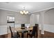 Elegant dining room featuring a modern glass table, hardwood floors, large windows and classic trim at 1548 Pinebreeze Dr, Marietta, GA 30062