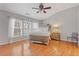 Sun-filled main bedroom features hardwood floors, a ceiling fan, and large windows at 1641 Hedington Ct, Lawrenceville, GA 30045