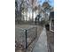 Large fenced backyard with tall trees, concrete walkway, and plenty of space for activities at 2720 Sandy Creek Cir, Loganville, GA 30052