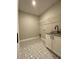 Well-lit laundry room with patterned tile floor, sink, and wire shelving at 642 Presley Farm Pkwy, Rockmart, GA 30153