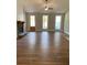 Open living area with a stone fireplace, wood floors, and large windows at 642 Presley Farm Parkway, Rockmart, GA 30153