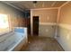 Under construction bathroom with a white bathtub and tiled walls underneath a large window at 642 Presley Farm Pkwy, Rockmart, GA 30153
