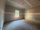 An unfinished bedroom featuring a large window shows a well-lit space, highlighting its potential at 642 Presley Farm Pkwy, Rockmart, GA 30153