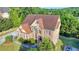 Aerial front view of a brick two-story home with a well-manicured lawn and a driveway at 1755 Riverpark Dr, Dacula, GA 30019